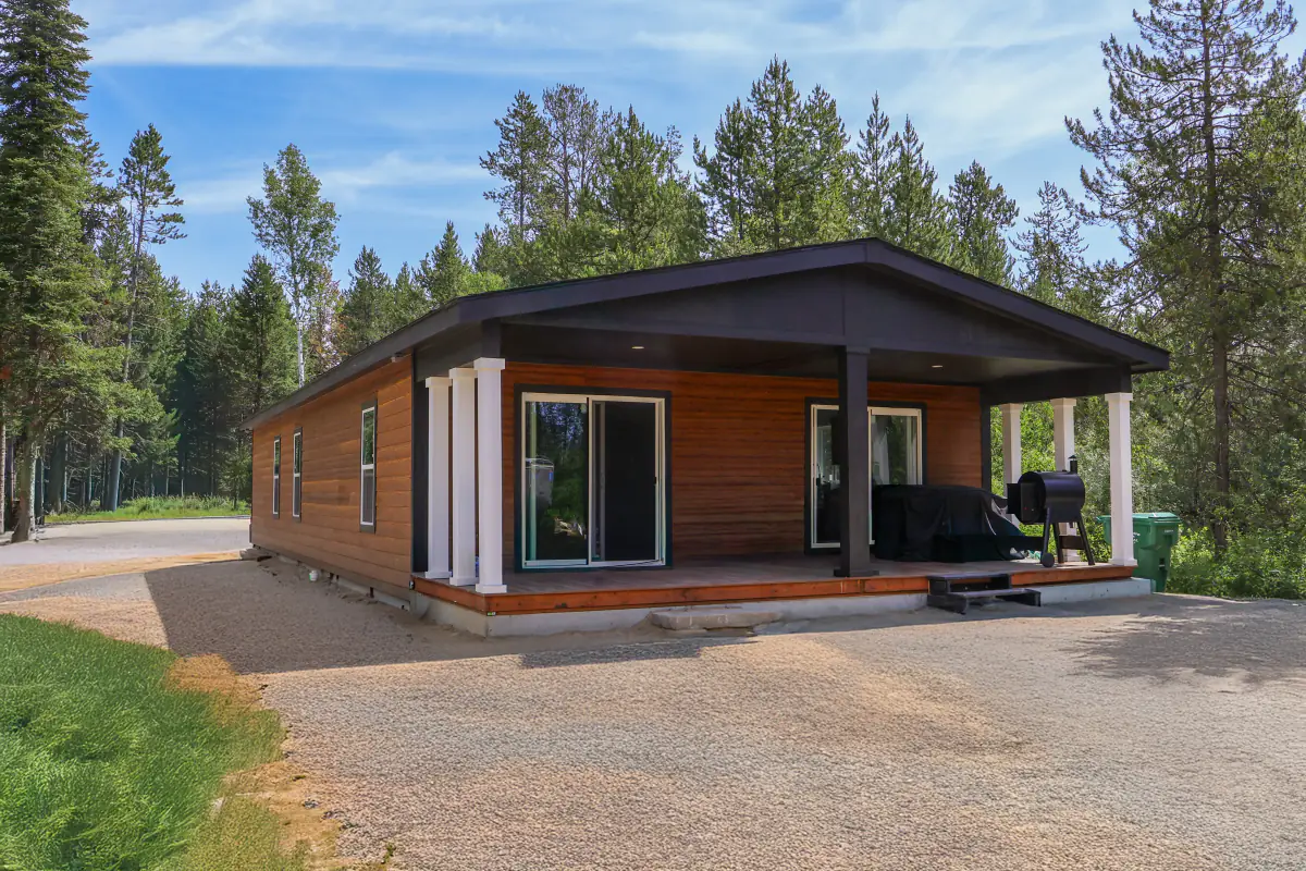Completed manufactured home with a covered porch in a wooded setting